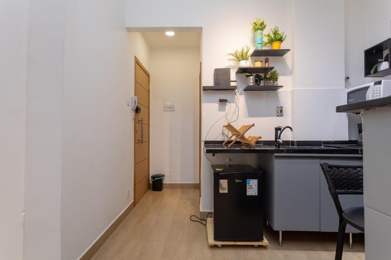 Entrada do estúdio em Copacabana, com corredor e cozinha compacta ao fundo