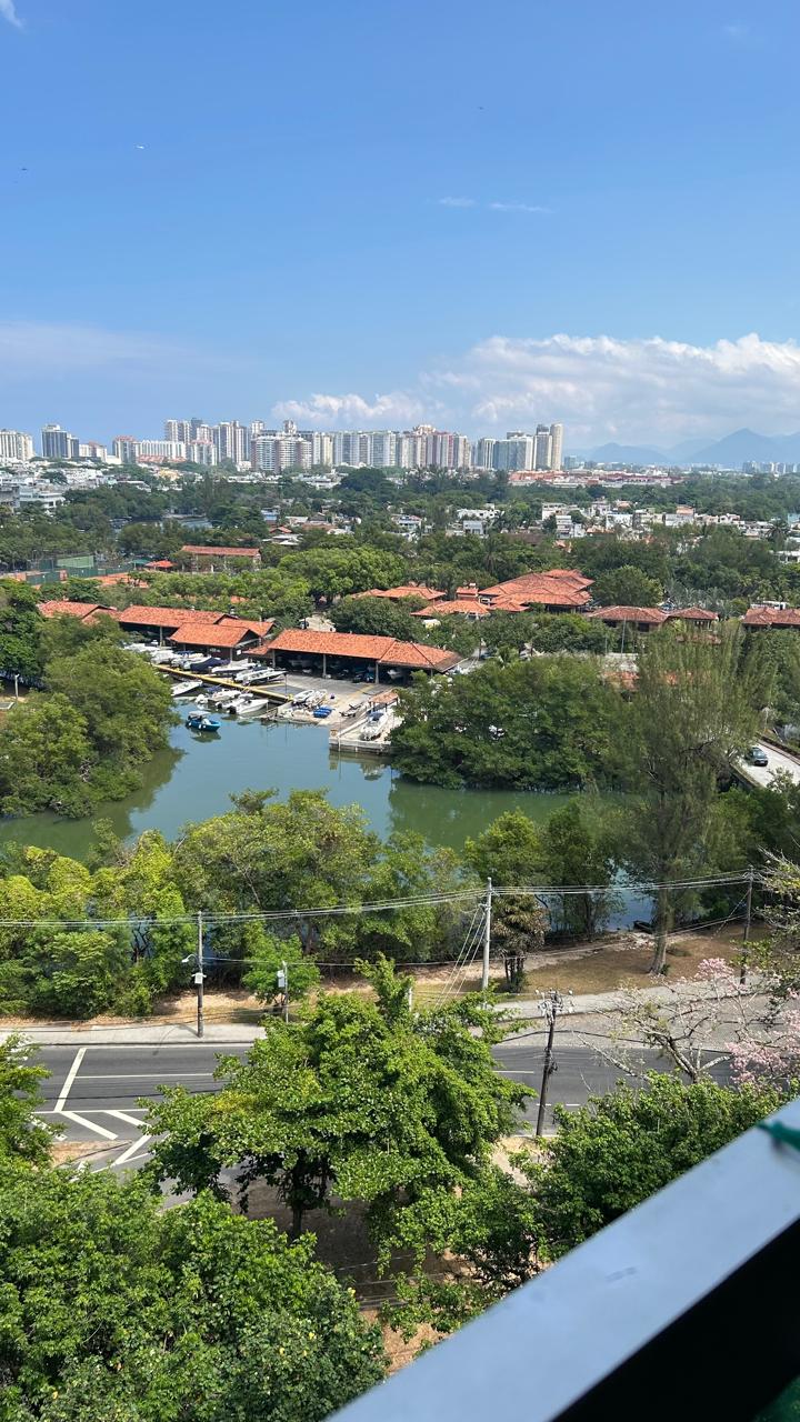 Vista aérea da região do apartamento em Copacabana, Posto 4, com canal, marina de barcos, telhados vermelhos e prédios ao fundo