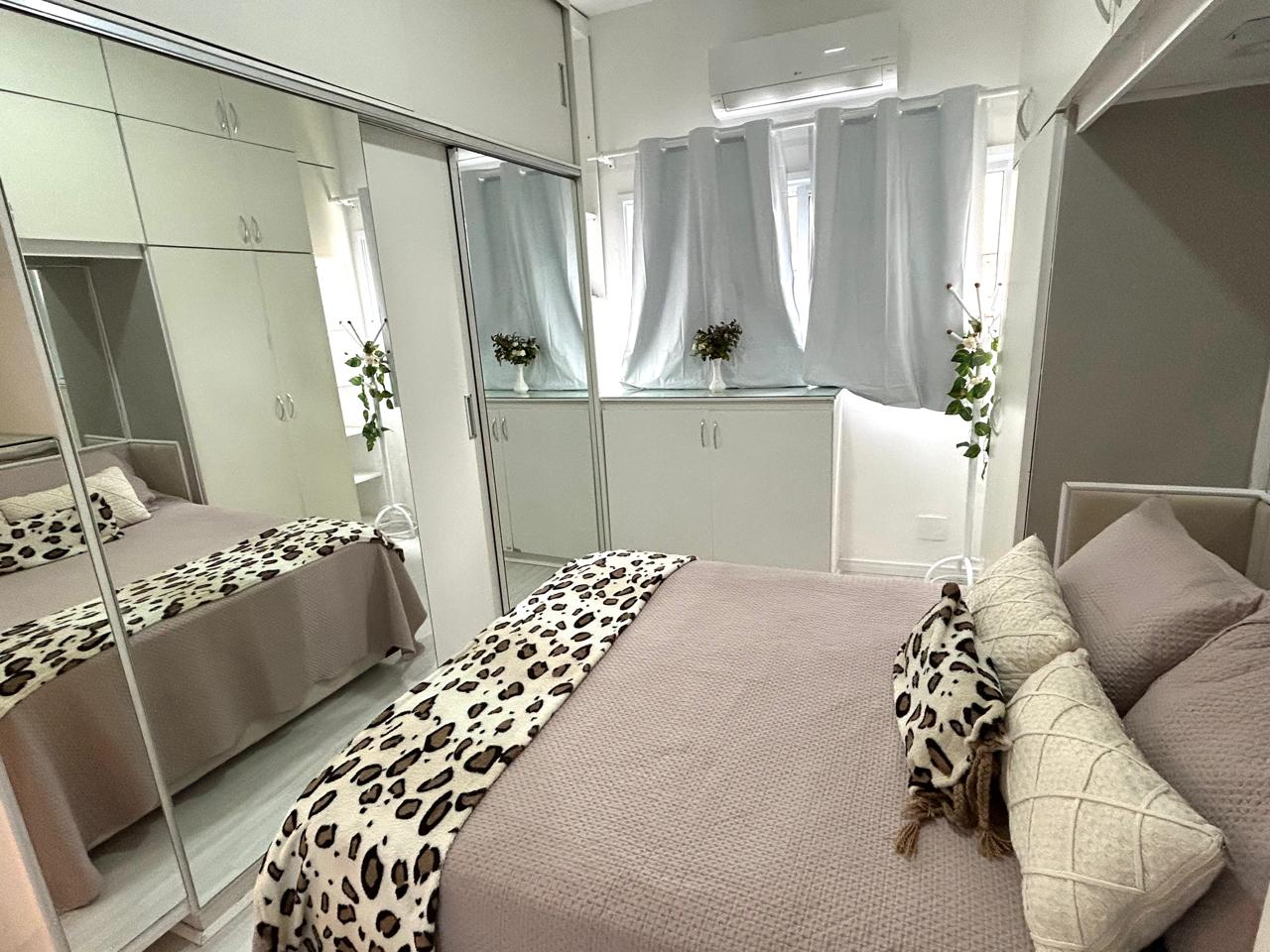 Suíte do apartamento em Ipanema, com cama de casal, guarda-roupa espelhado e ar-condicionado