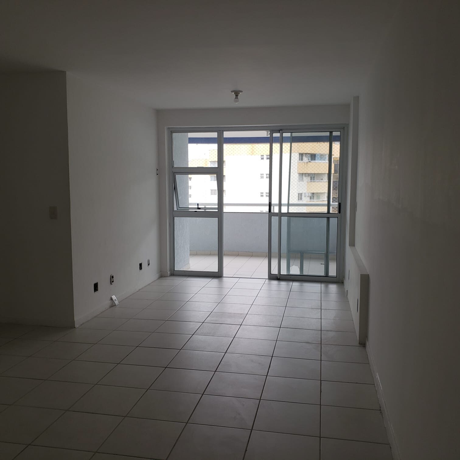 Sala do apartamento na Vila do Pan vista de outro ângulo, com a varanda ao fundo